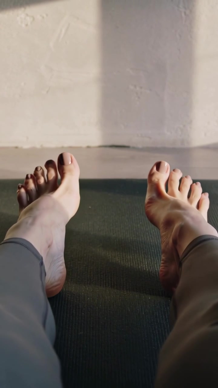 Pystyvideo: Nilkkarutiinin aloitus, henkilö taivuttaa jalkateriään matolla kotona, varvassormus ja leggingsit.