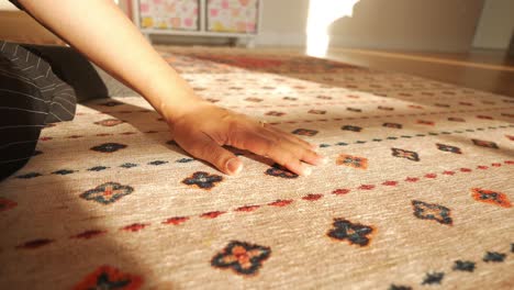 a woman sitting on a rug in a sunny room