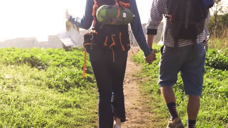 young lovely couple backpackers tourists walking holding hands toward roman aqueduct arches in parco degli acquedotti park ruins in rome on romantic misty sunrise with guitar and sleeping bag slow motion