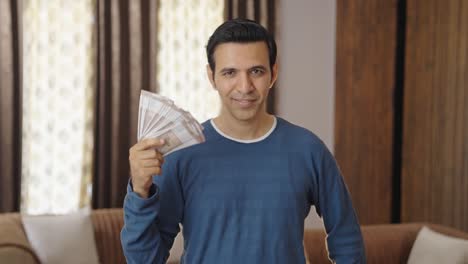 Rich-Indian-man-using-money-as-fan