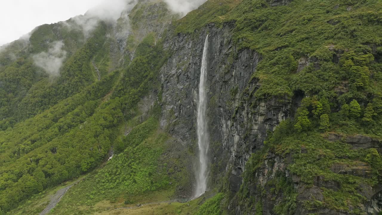 velo de novia cae cascada alta a lo largo de un acantilado de roca escarpada en nueva zelanda, antena