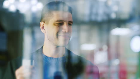 a man with a credit card in his hand stands at window of a boutique