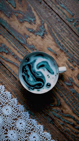 stylish coffee art in a cup on wooden table with lace