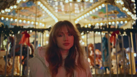 woman standing illuminated carousel luna park at night closeup looking lights