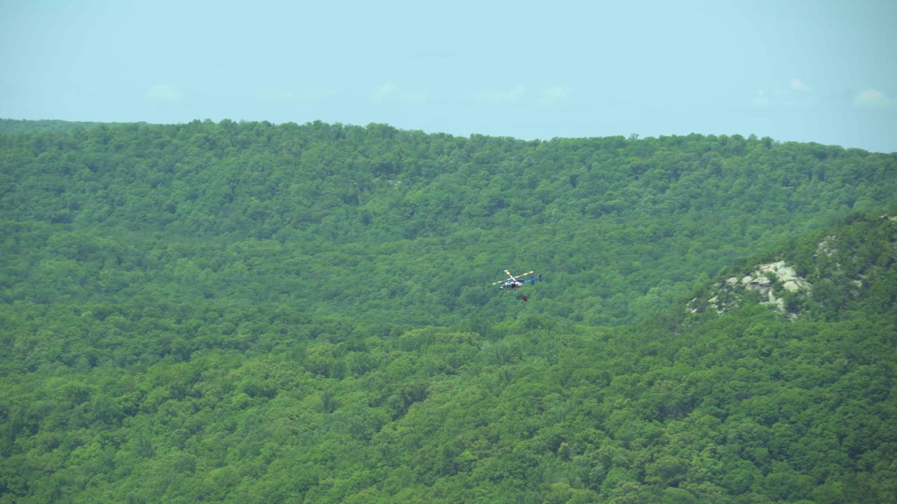 수송 중인 물 버 을 고 있는 소방 헬리터 의 공중 사진