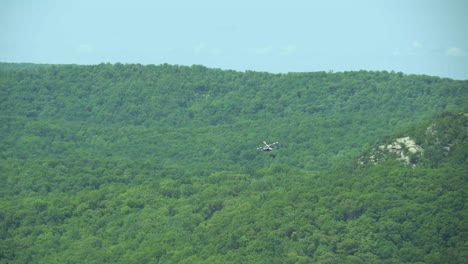 vista aérea de un helicóptero de extinción de incendios con un cubo de agua en transporte