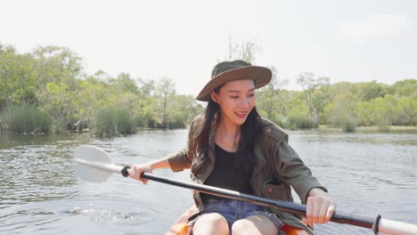 mujer en kayak en un río pintoresco