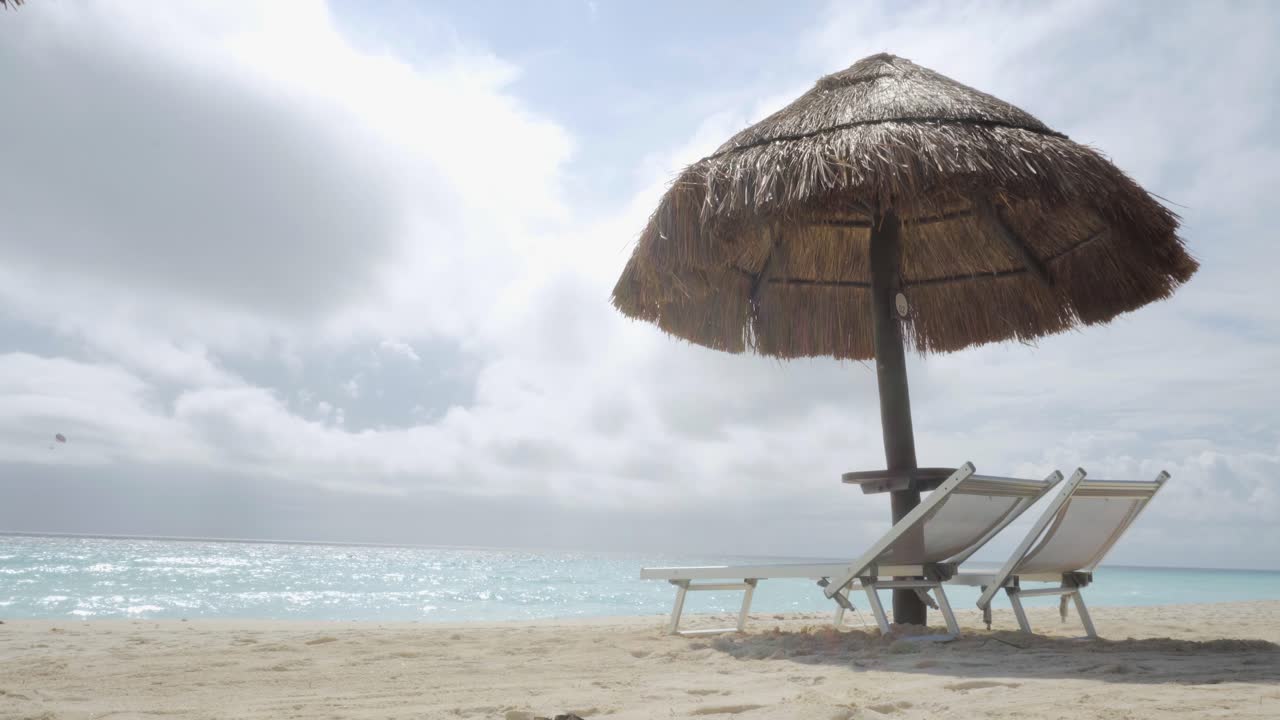 hombre conduciendo un quad en la playa pasando por tumbonas y sombrillas