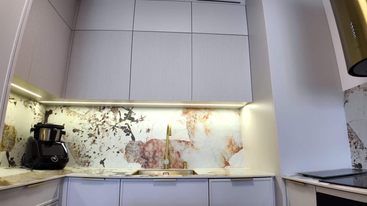 Modern Kitchen Interior with Stone Backsplash and Gold Accents