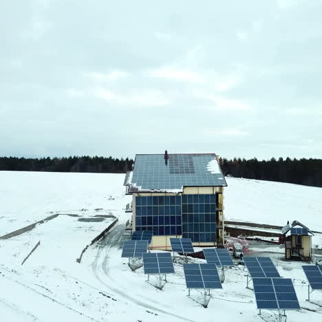 hotel complex in the mountains with solar panels on the snow. rows of snow covered solar panels in a small solar power plant.