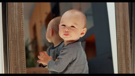 baby exploring and playing with reflection in the mirror