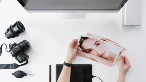 vista superior fotógrafo diseñador gráfico eligiendo imágenes de belleza trabajando en el escritorio desde arriba - dragón épico rojo
