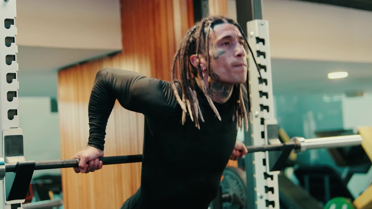 Athletic Man with Dreadlocks Performing Dips in Modern Gym