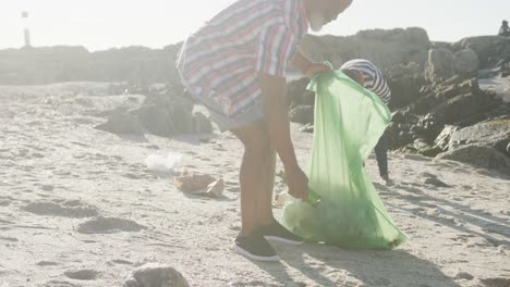 una pareja afroamericana de alto nivel limpiando la playa, cámara lenta