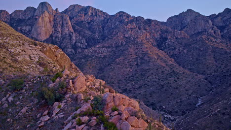 drone shot panning around mountain peak with desert flora on top