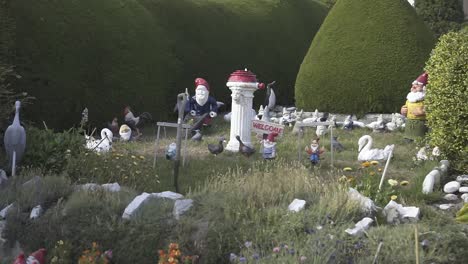 gnome holding a carrot stands in a grassy field surrounded by other cheerful gnomes, creating a whimsical garden scene