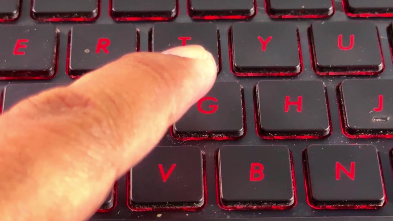 Close-up footage of hand interacting with laptop keyboard in "G" button, perfect for office, freelance, and online work content.