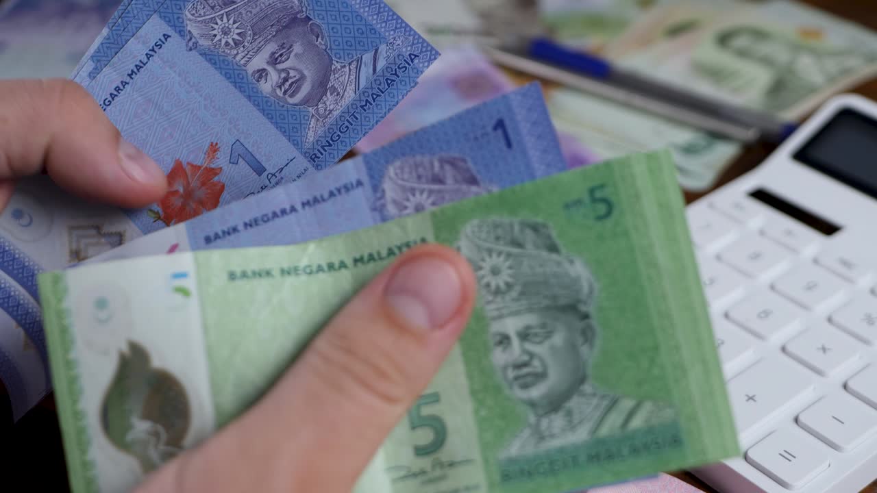 Tangan akuntan menghitung ringgit MYR Malaysia.