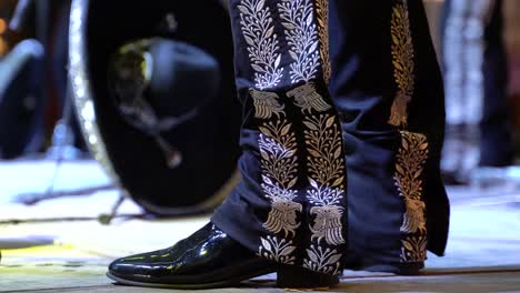 Focus-on-Mariachi-costume,-charro-decoration-of-pants-and-shoes-of-trumpet-player-in-a-stage-performance-in-Merida,-Yucatan,-Mexico