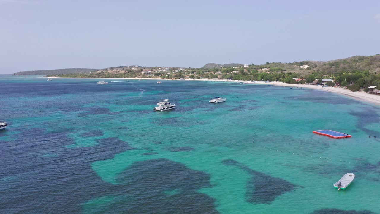 Splendido Mar Caraibico turchese con barche da diporto al largo di una spiaggia tropicale