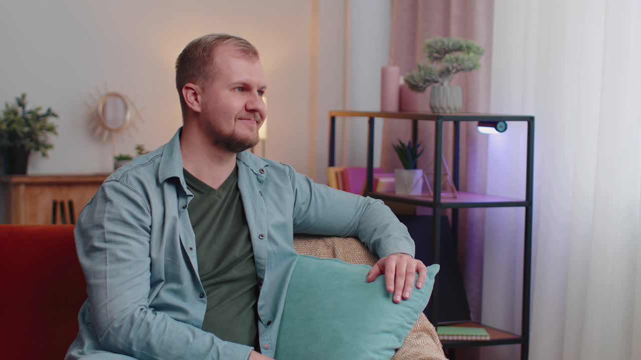 feliz y tranquilo adulto caucásico hombre barbudo sonriendo mirando hacia otro lado soñando descansando, sintiéndose satisfecho en casa