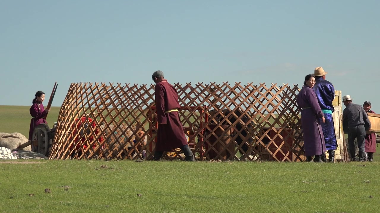 Mongolisk nomadfamilj som monterar ett traditionellt gertält