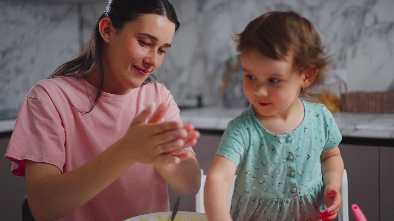 A Creative Cooking Experience: A Heartwarming Moment Between a Mother and Her Young Daughter in the Kitchen, Enjoying Baking Together with Joyful Laughter and Playful Engagement