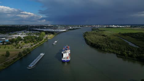 aerial panoramic view of river with cargo ships and surrounding flat landscape