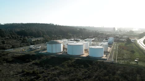 Aerial-orbit-of-white-oil-tanker-containers-at-sunset