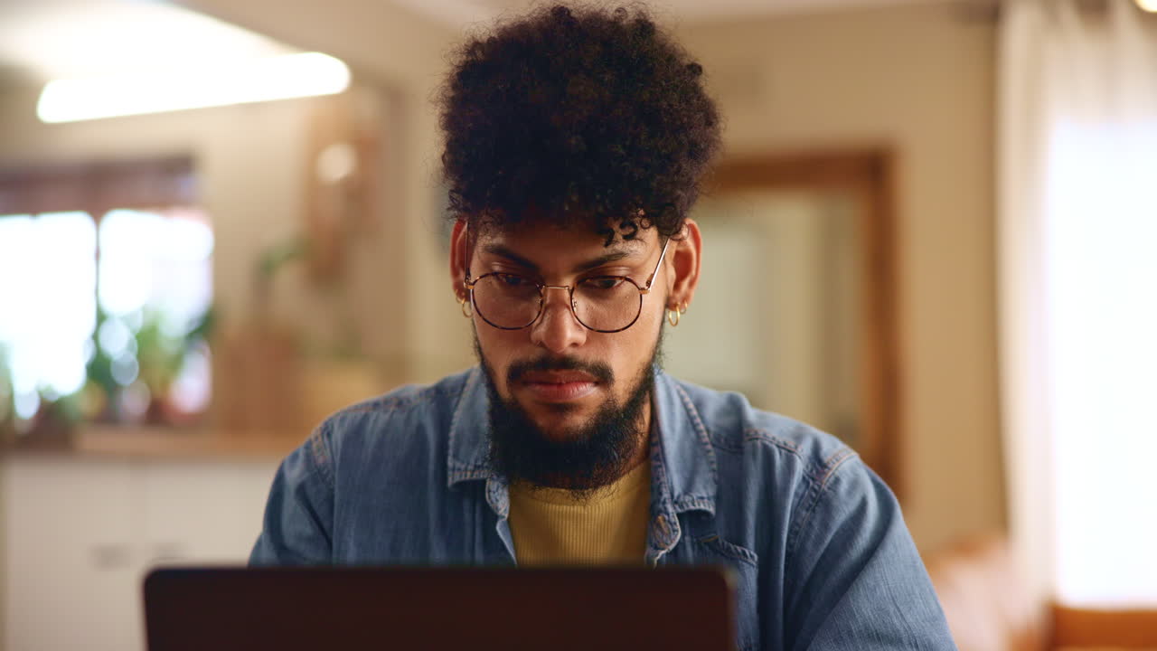 un hombre trabajando en su portátil en casa