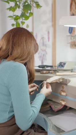 woman working on jewelry at a workshop bench