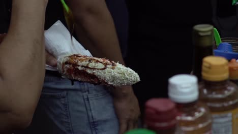 trabajador latino preparando comida típica mexicana para el cliente en el puesto de la calle