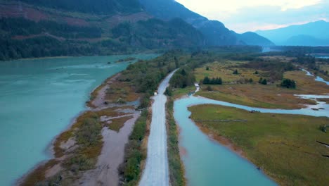 vista aérea del paisaje de canadá del área de conservación de squamish spit al atardecer con camino de ripio estrecho y vista panorámica de las montañas