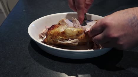 man pulling chicken apart - chicken not properly cooked