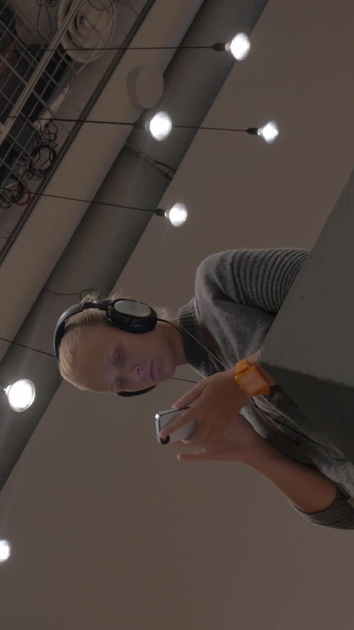 Young Woman with Headphones Using Smartphone Indoors