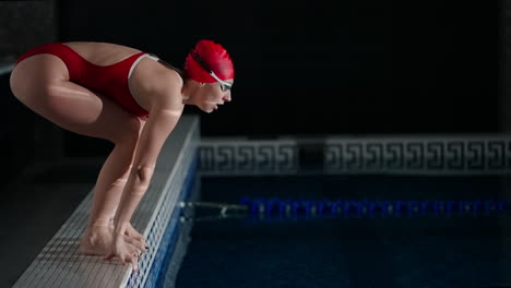 mujer en traje de baño rojo nadando en la piscina cubierta