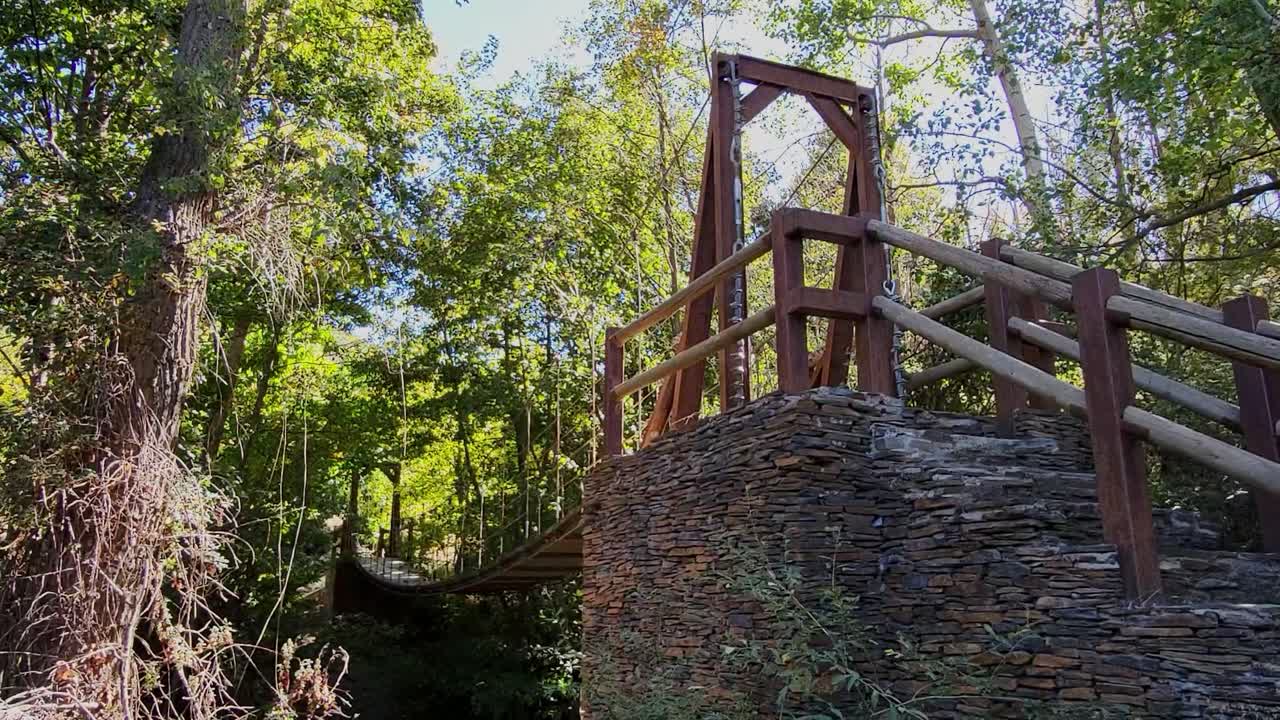 Ponte sospeso su un fiume, realizzato in pietra, legno, struttura metallica e cavi d'acciaio. Architettura, costruzione di ponti. Ingegneria dei ponti. Spagna