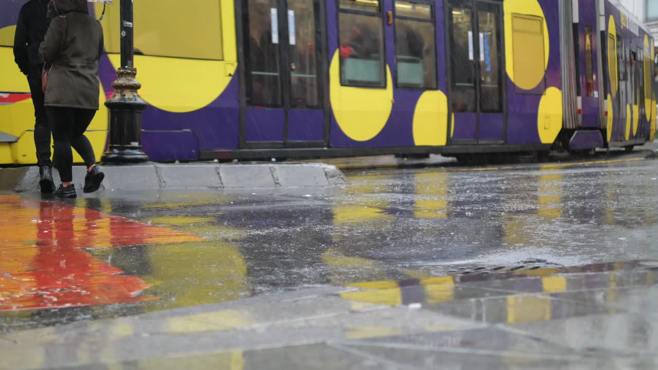 배경 에 트램 이 있는 은 거리 를 고 있는 사람 들