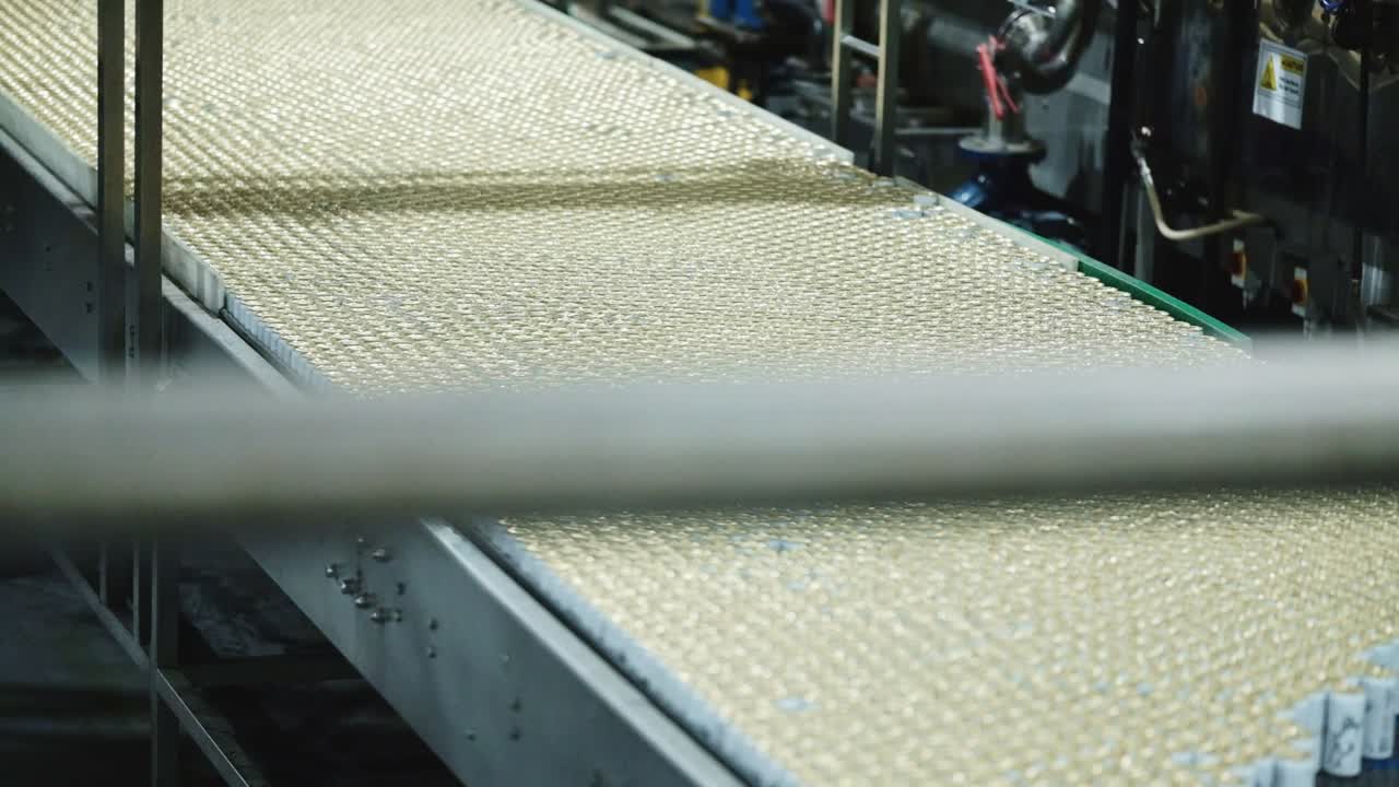 Beverage cans moving along a conveyor belt in a large factory