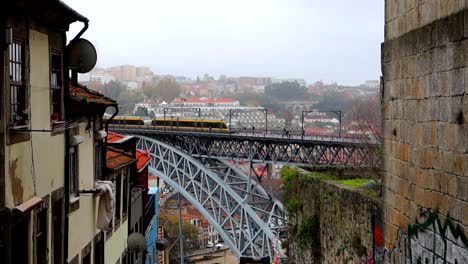 yellow train crossing iconic ponte dom luis i in porto