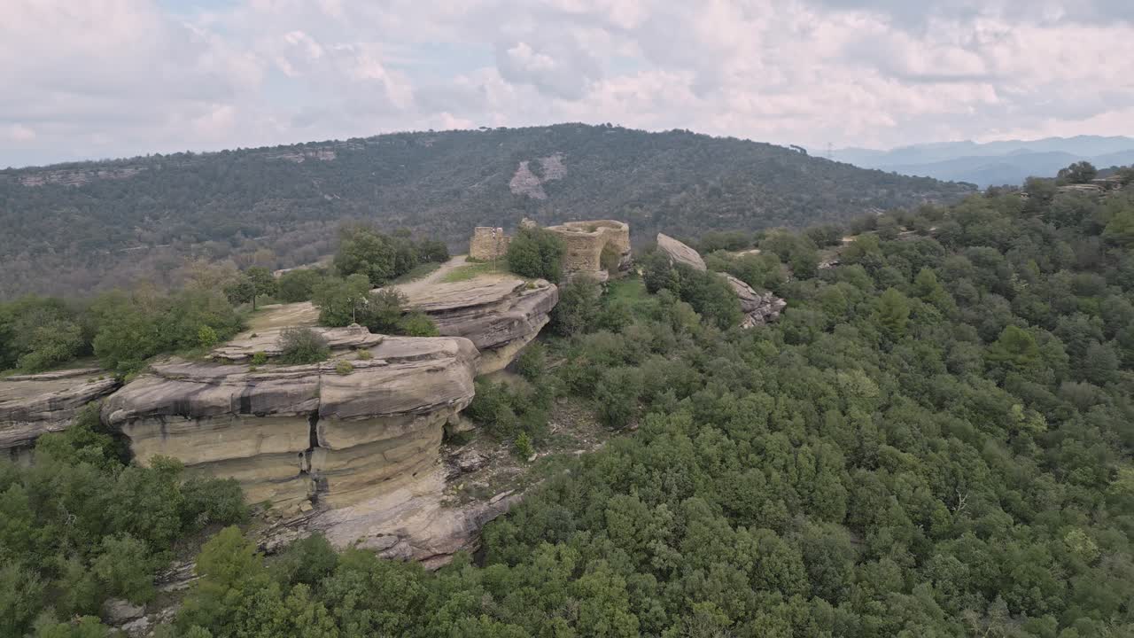 Scenic views of the eighth century taradell castle ruins perched atop a rocky outcrop, surrounded by lush green forests and rolling hills, showcase the historical landmark in catalonia, spain
