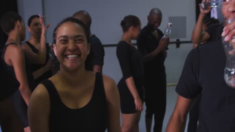 grupo multiétnico de bailarines modernos en forma masculinos y femeninos tomando un descanso