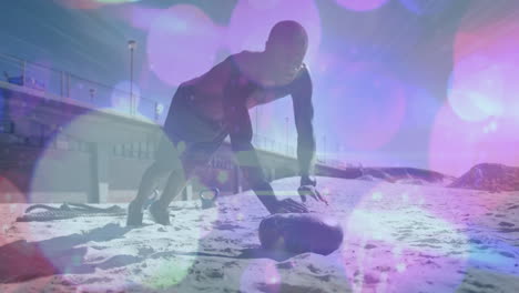 manchas púrpuras de luz contra afroamericano hombre en forma realizando ejercicios de empuje en la playa