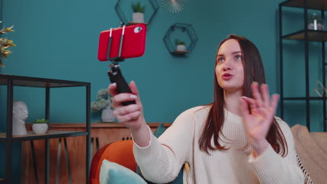 Girl-blogger-influencer-taking-selfie-on-smartphone,-make-virtual-social-media-video-online-at-home