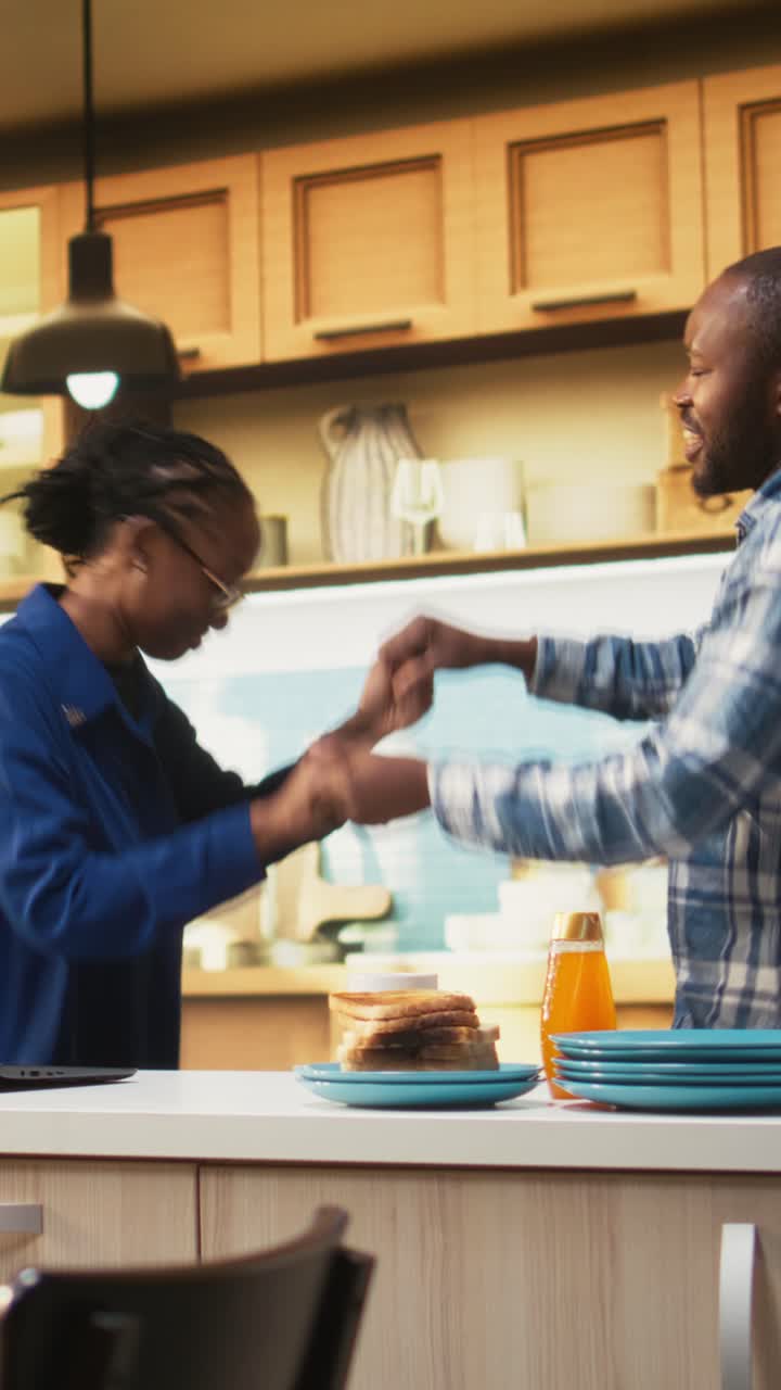 Vertical Video Smiling black man and woman sharing a romantic dance in the kitchen
