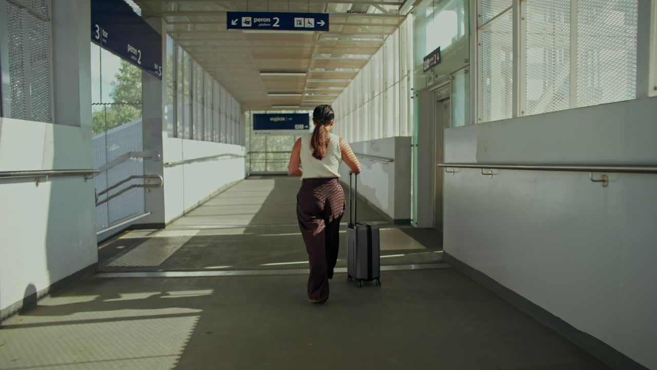 Una mujer caminando por una pasarela con equipaje