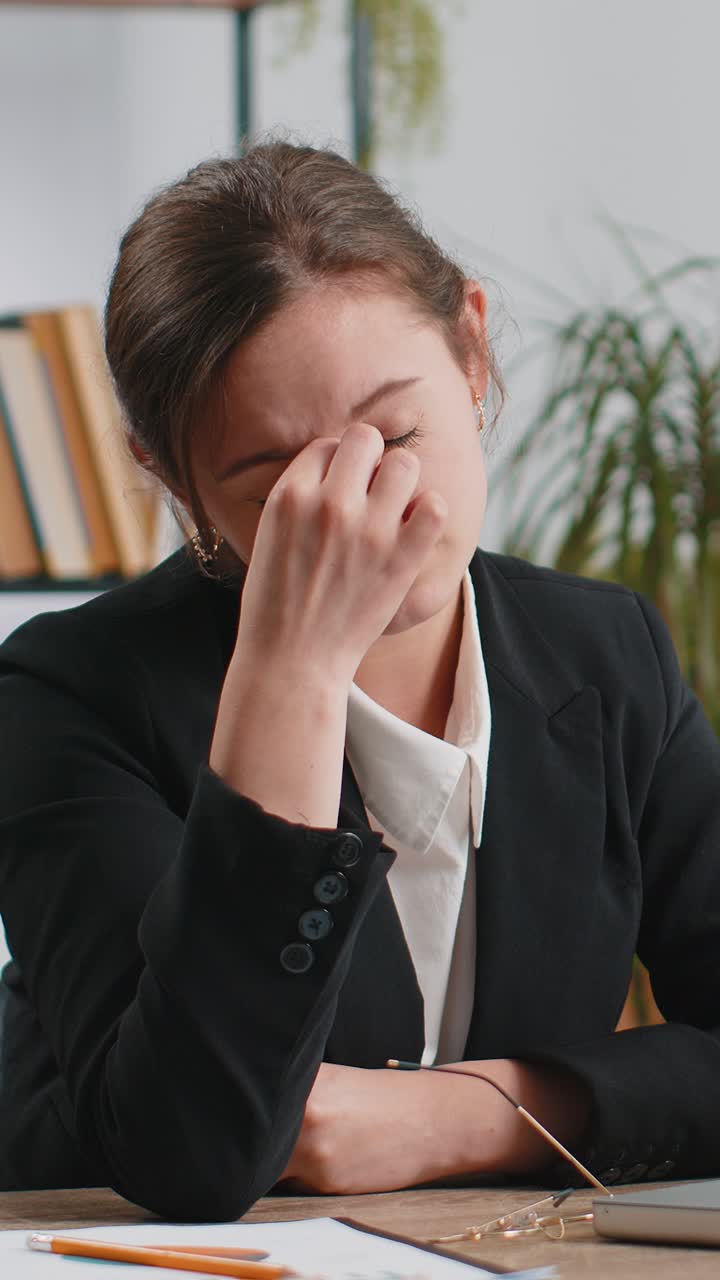 Donna d'affari caucasica stanca, afflitta da mal di testa, tensione, emicrania e stress in ufficio.