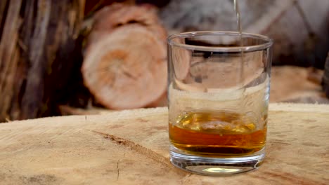 Canadian-Club-1858-whiskey-mixed-with-coke-ice-splash-with-wood-background,-1920x1080-25fps