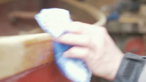 wiping the gunwale of a canoe preparing for finishing