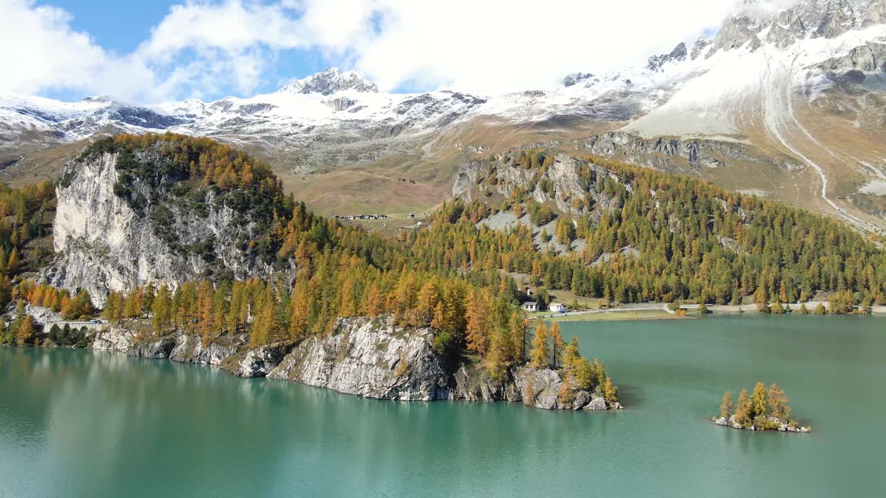 Stunning drone footage of the lake Sils (Silsersee) in Upper Engadine, Grisons, Switzerland,in Autumn with the snowy mountains as a backdrop.